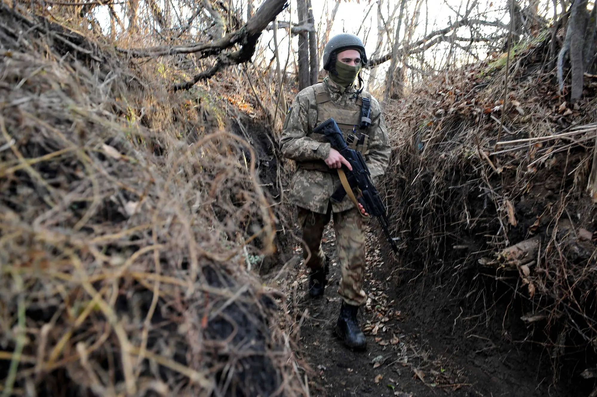 Ukrainian serviceman walks along trench