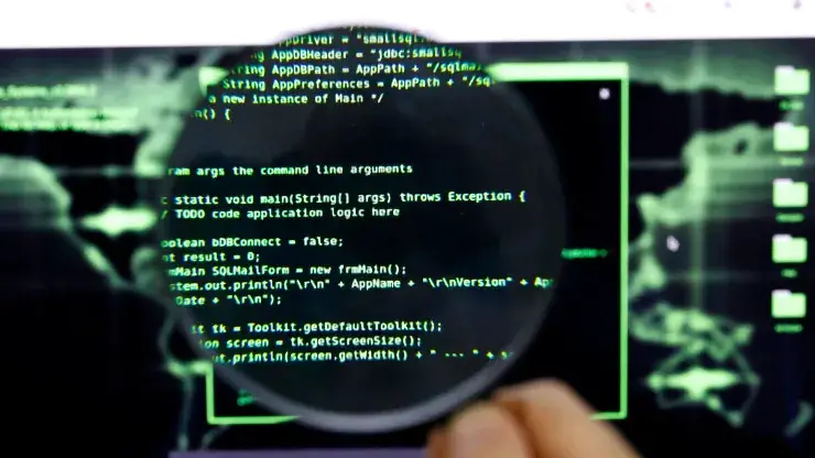 Holding a magnifying glass over a computer screen