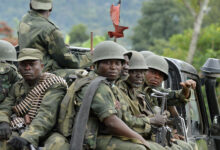 Democratic Republic of Congo army soldiers sit at the back of a pick-up truck as they head towards the Mbuzi hilltop