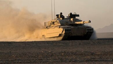The British Challenger 2 MBT of the 1st Royal Tank Regiment glides effortlessly across soft sand with the low evening light of the Omani landscape glinting off the desert camouflage