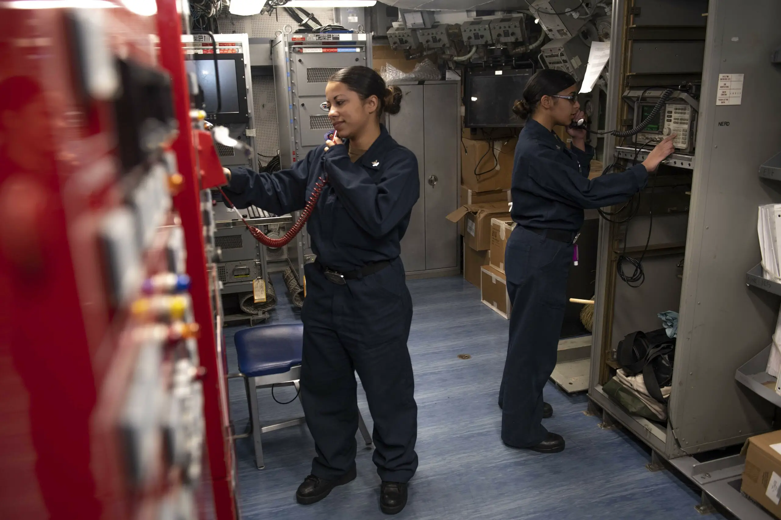 190914-N-PX867-1031 GULF OF ADEN (Sept. 14, 2019) Information Systems Technician 2nd Class Erika Clark, left, and Information Systems Technician 3rd Class Ainesey Iguanzo, both assigned to amphibious assault ship USS Boxer (LHD 4), conduct a communications check in the radio shop. Boxer is part of the Boxer Amphibious Ready Group and 11th Marine Expeditionary Unit and is deployed to the U.S. 5th Fleet area of operations in support of naval operations to ensure maritime stability and security in the Central Region, connecting the Mediterranean and the Pacific through the Western Indian Ocean and three strategic choke points. (U.S. Navy photo by Mass Communication Specialist 3rd Class Justin Whitley/Released)