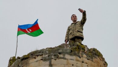 An Azerbaijani soldier takes a selfie with the national flag in Fuzuli, a liberated city, last November 26, 2020.