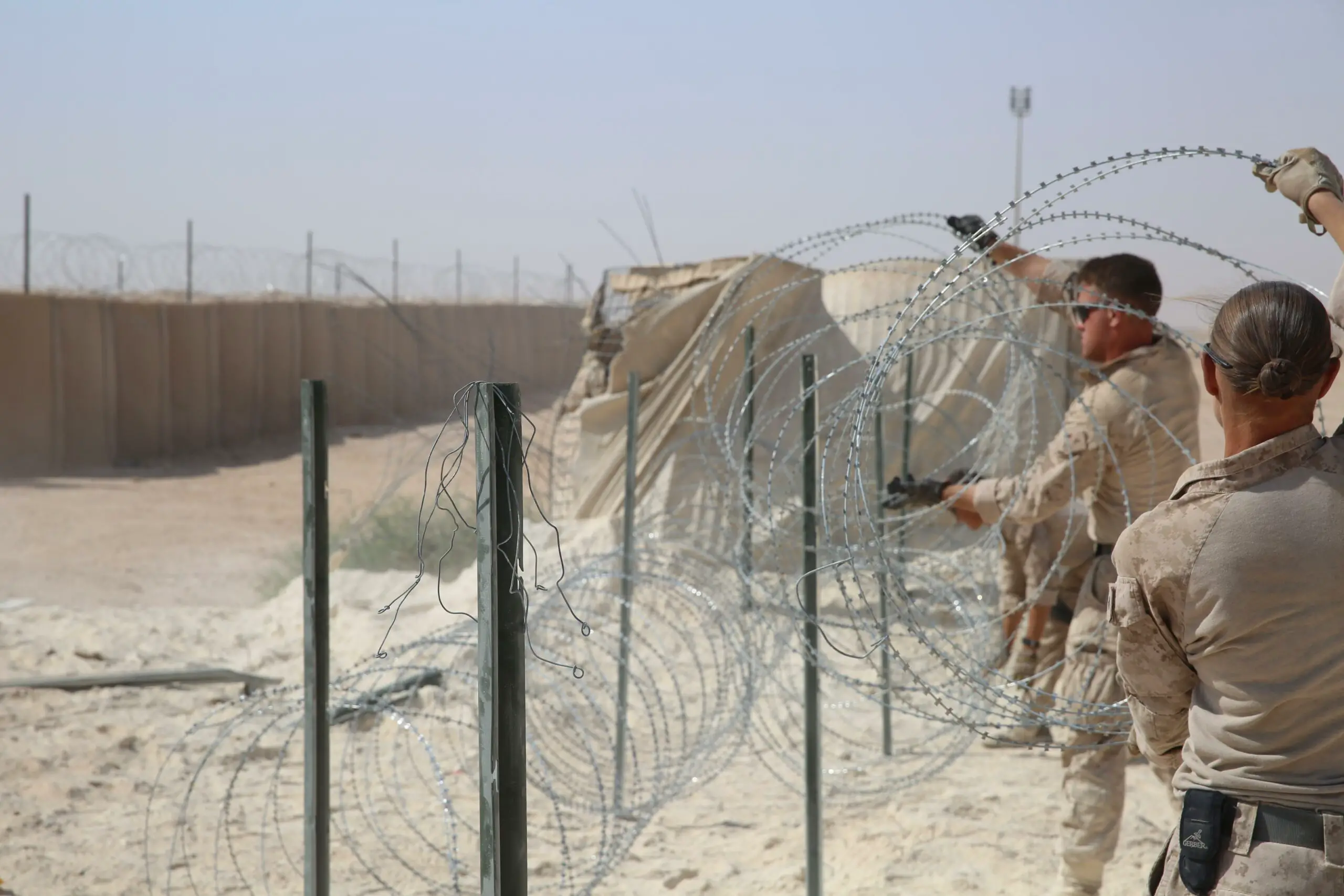 US Marine Corps combat engineers improve force protection measures by laying concertina wire at Al Asad Air Base, Iraq