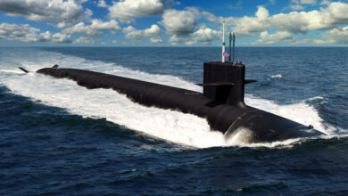 An artist rendering of a Columbia-class nuclear submarine breaching the surface. The top half of the submarine can be seen above the water surrounding it.