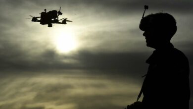 Photo of a man flying a drone.