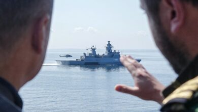 German Chancellor Olaf Scholz speaks with a serviceman as he stands aboard the frigate Mecklenburg-Vorpommern during his visit of the German Navy during a military maneuver in the Baltic Sea near Rostock-Warnemünde, northeastern Germany