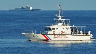 A Philippines' coast guard ship sailing past a Chinese coast guard ship during a joint search and rescue exercise between the Philippines and US coast guards near Scarborough Shoal in the South China Sea
