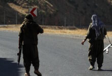 A member of the Kurdistan Workers' Party (PKK) carries an automatic rifle on a road in the Qandil Mountains, the PKK headquarters in northern Iraq, 2018