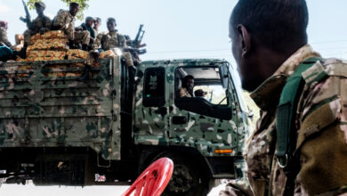 Members of the Amhara Special Forces seat on the top of a truck while another member looks on in the city of Alamata, Ethiopia, on December 11, 2020