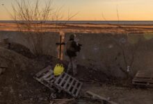 Ukrainian servicemen stand guard at a position next to the Dnipro River