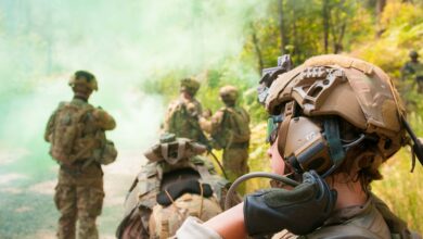A soldier reaches for her drink tube during an operational test of the Integrated Head Protection System