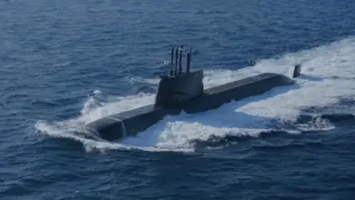ROKS Dosan Ahn Changho (SS-083), a Jangbogo-III class submarine, is seen floating half-submerged in deep blue waters. The ship is painted black. A South Korean flag is seen hoisted up on a pole on top of the submarine's sail.